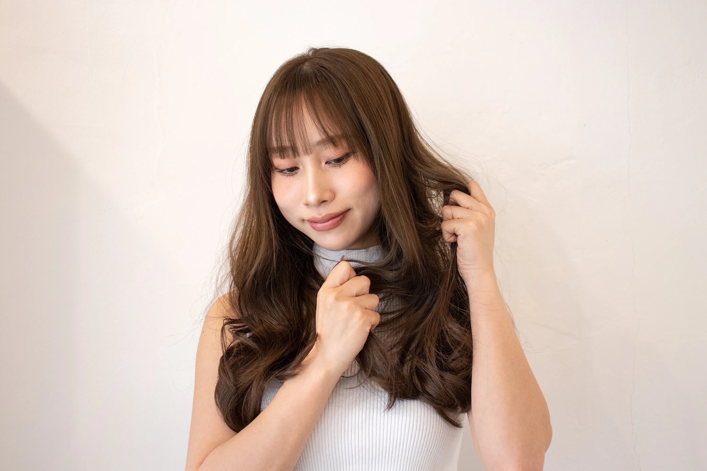画像：毛束をつかむように髪の内側からなじませる